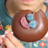 Angebissener Paleta Payaso von einer Kinderhand gehalten